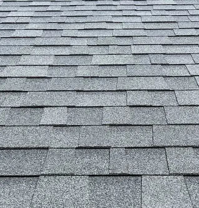 Close-up of clean gray asphalt shingles with no moss or streaks after roof cleaning.